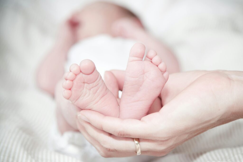 pexels-photo-325690-325690 Tender photo of a mother's hands holding her newborn's feet, symbolizing love and care.